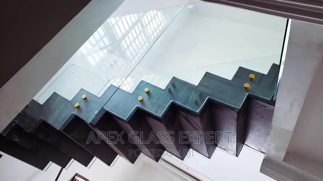 Staircase Glass With Gold Railing Support.