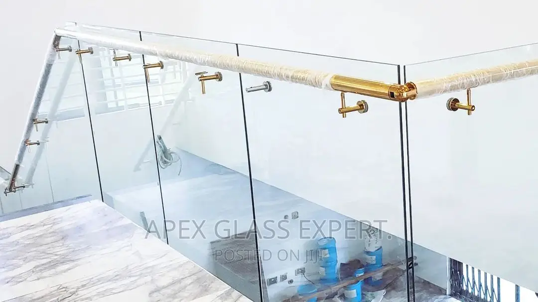 Staircase Glass With Gold Railing Support.