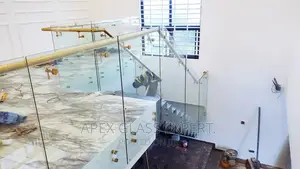 Staircase Glass With Gold Railing Support.