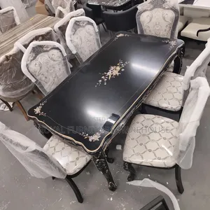 Rococo-Style Black Dining With Floral Accents and Upholstered Chairs.